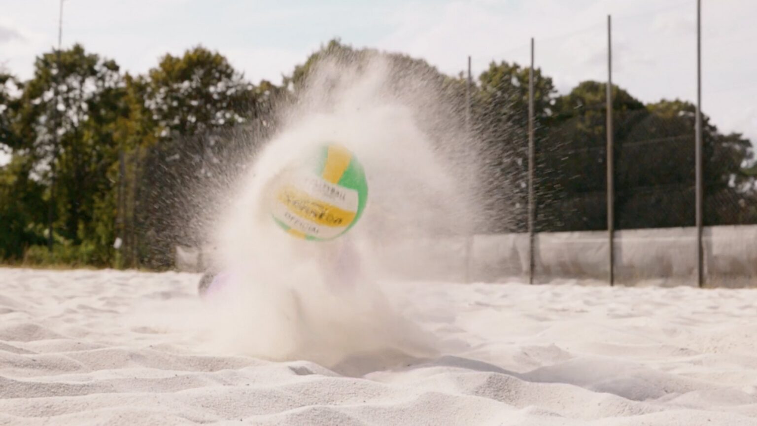Volleyball schlaegt im Sand auf, Zeitlupe aus einem Werbespot